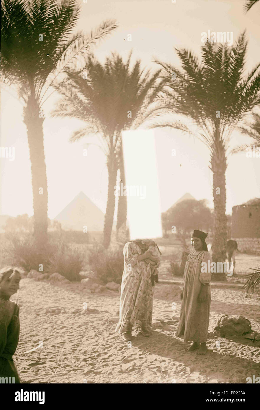 L'Égypte. Types d'agriculture. Paysan avec leurs enfants à Palm Grove (montrant des pyramides). 1934, l'Égypte Banque D'Images