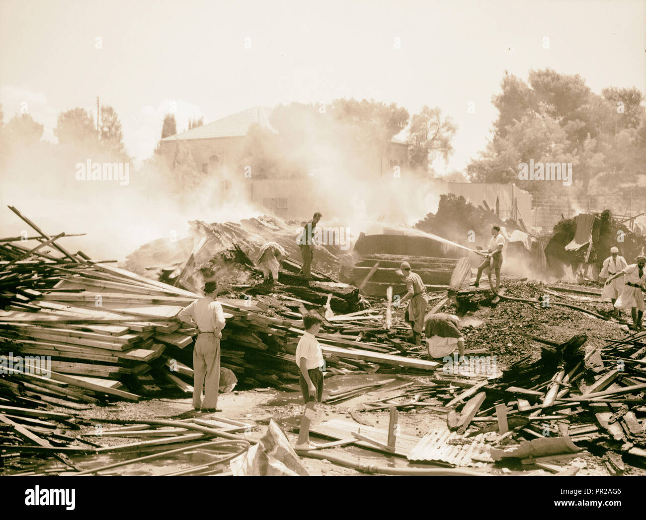 Même le feu, nuit d'incendiaires et de charbon près de chantiers de bois d'railroad station, brûle encore sur matin suivant. 1938, Israël Banque D'Images