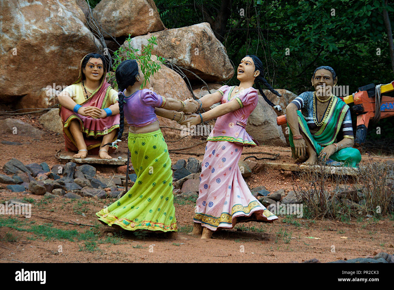 Icônes de filles jouant allègrement jeu tourbillonnant et frère mesdames les regarder au jardin près de Alamatti Dam, District Bagalkot, Karnataka, Inde, Asie Banque D'Images