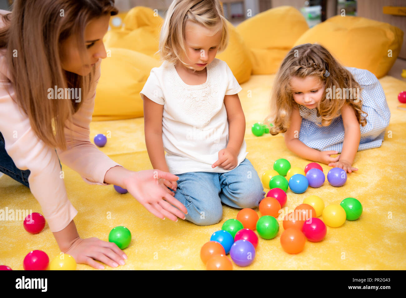 Pointant l'éducateur sur boules colorées pour les enfants en maternelle Banque D'Images