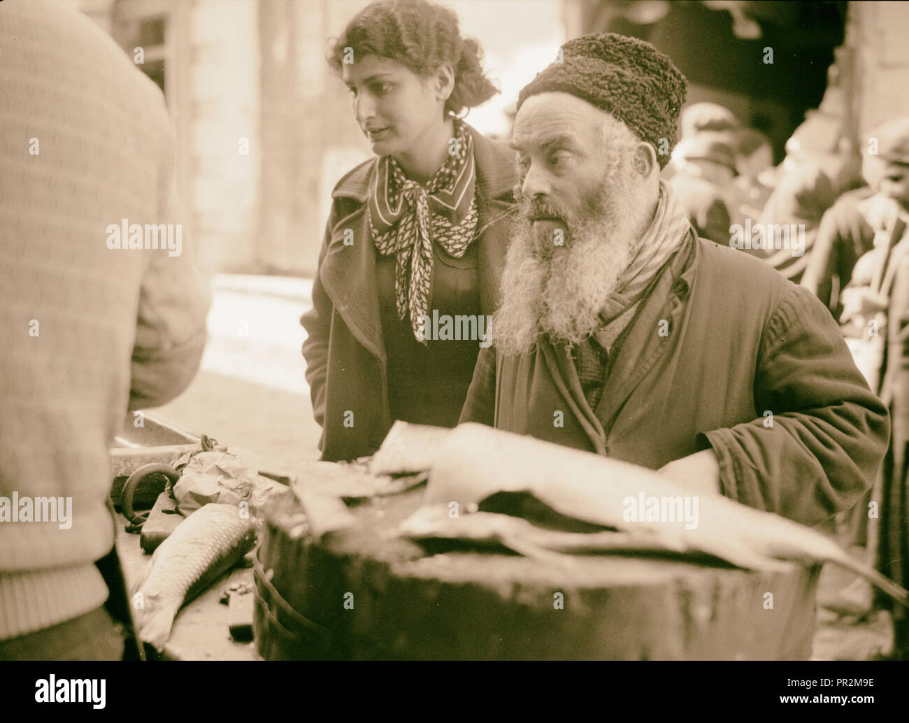 Types de juifs. L'étal d'un poissonnier juif et clients 1934, Israël Banque D'Images