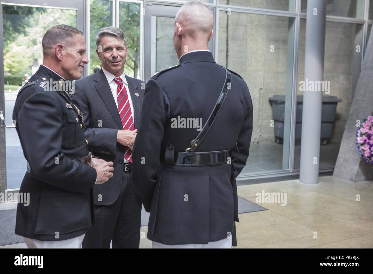 De gauche à droite, le Corps des Marines américains Le Lieutenant-général Robert S. Walsh, commandant général, Marine Corps Combat Development Command, et commandant adjoint, le développement des méthodes de combat et de l'intégration, Rép. américain Robert J. Wittman, le membre du Congrès du 1er district de Virginie et le Colonel Tyler J. Zagurski, commandant de Marine Barracks, Washington, la parole au cours d'une parade au coucher du soleil accueil à l'égard des femmes dans le service militaire pour l'Amérique, Memorial Arlington, Va., 25 juillet 2017. Coucher de défilés ont lieu comme un moyen d'honorer les hauts fonctionnaires, les éminents citoyens et partisans du Marine Corps. Banque D'Images