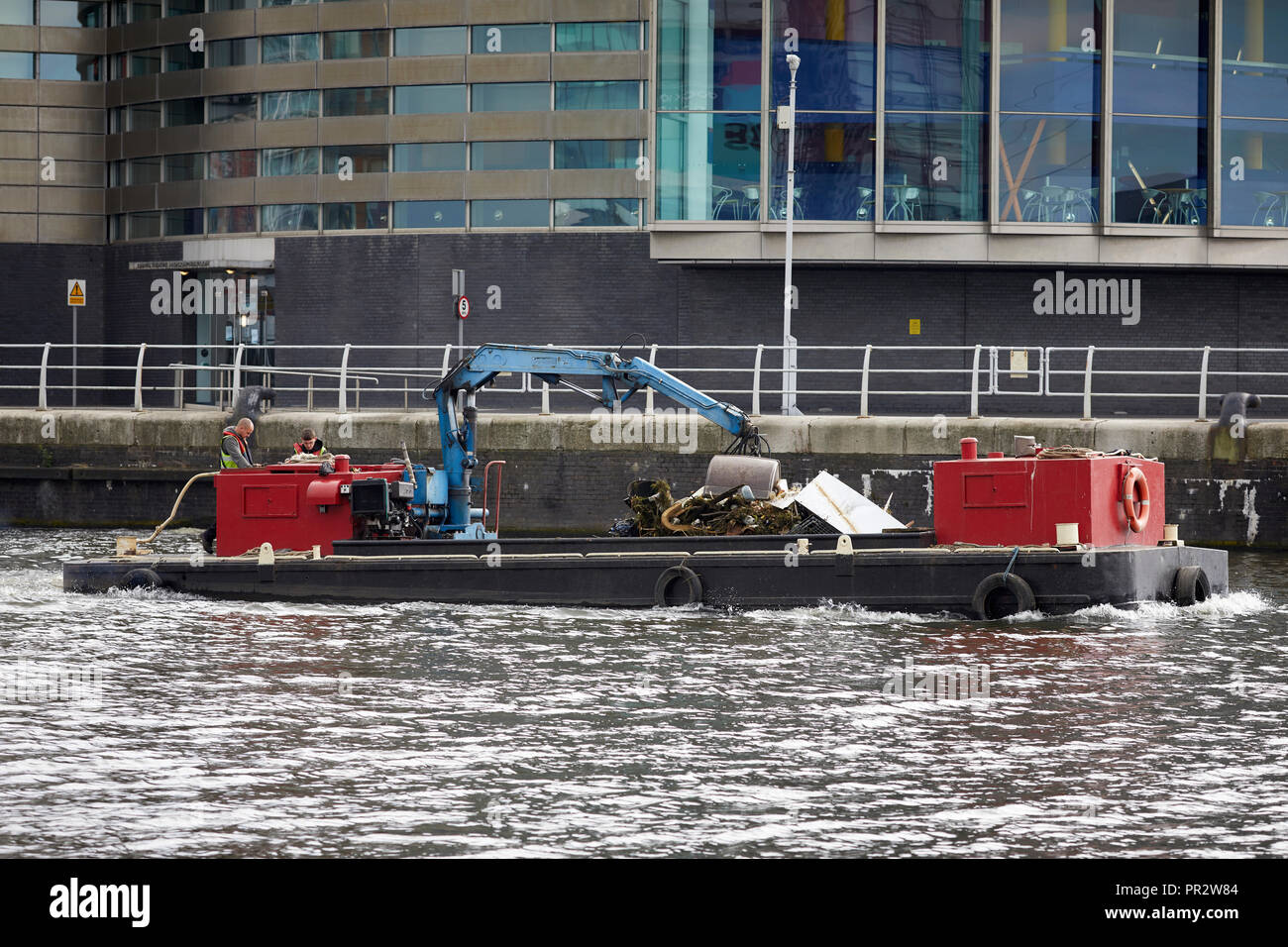 Collecte des déchets à bateau sur la MediaCityUK Manchester Ship Canal, à l'intérieur d'un bassin, Salford Quays Banque D'Images