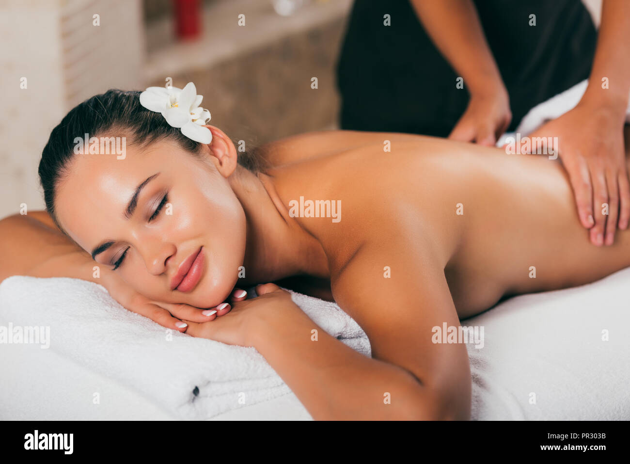 Smiling woman having massage thérapeutique au spa salon Banque D'Images