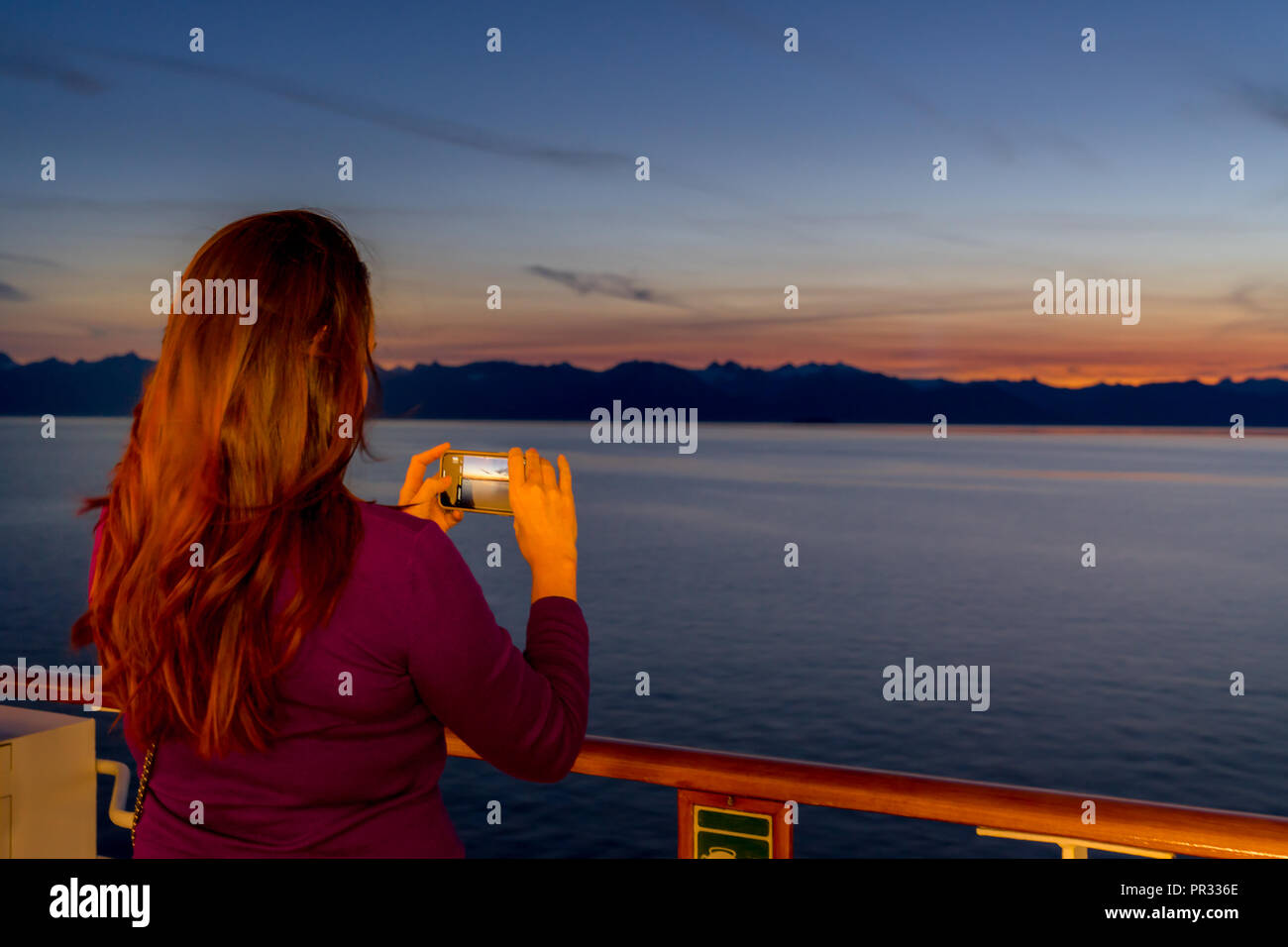 Juneau, Alaska, USA - Aug 20, 2018. Girl taking photo coucher du soleil de l'Alaska cruise ship Banque D'Images
