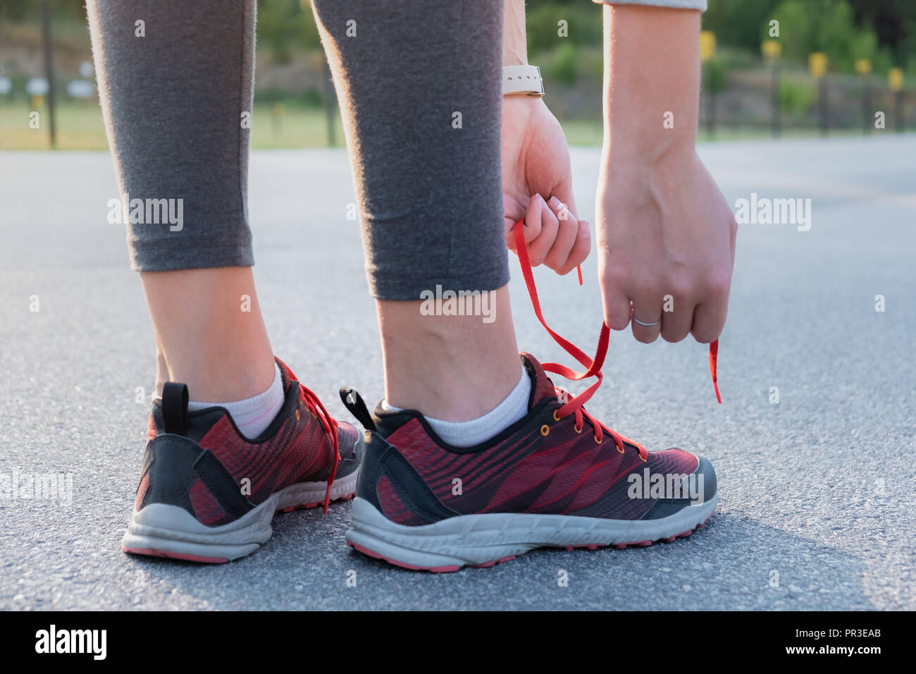 Le lacage des chaussures de course. Close-up of woman mains qui chaussent  des formateurs à l'extérieur dans un parc Photo Stock - Alamy