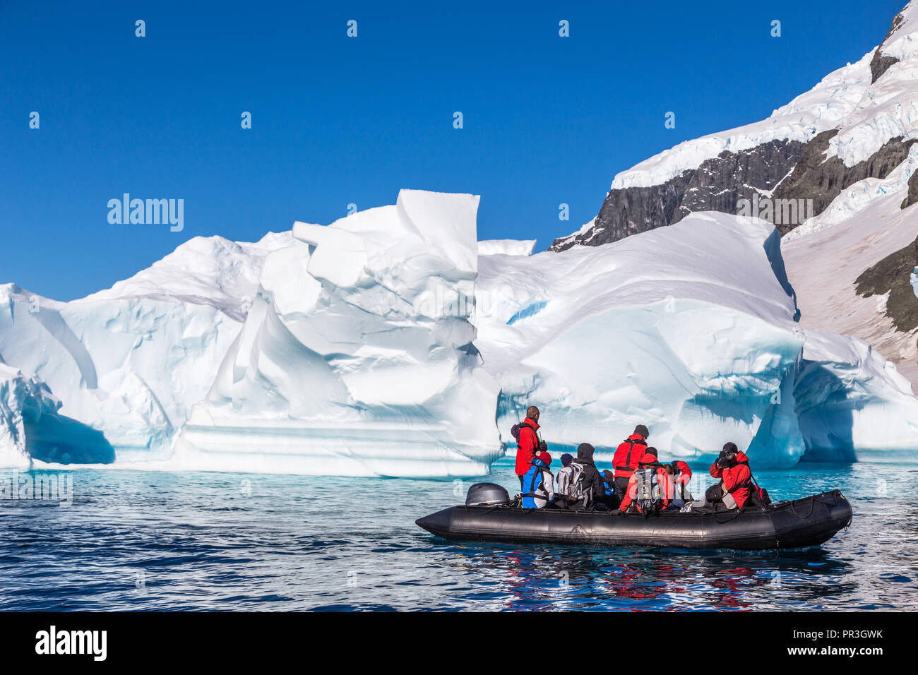 Voile plein de touristes explorer d'énormes icebergs à la dérive dans la baie près de Cuverville island, Antarctic peninsula Banque D'Images