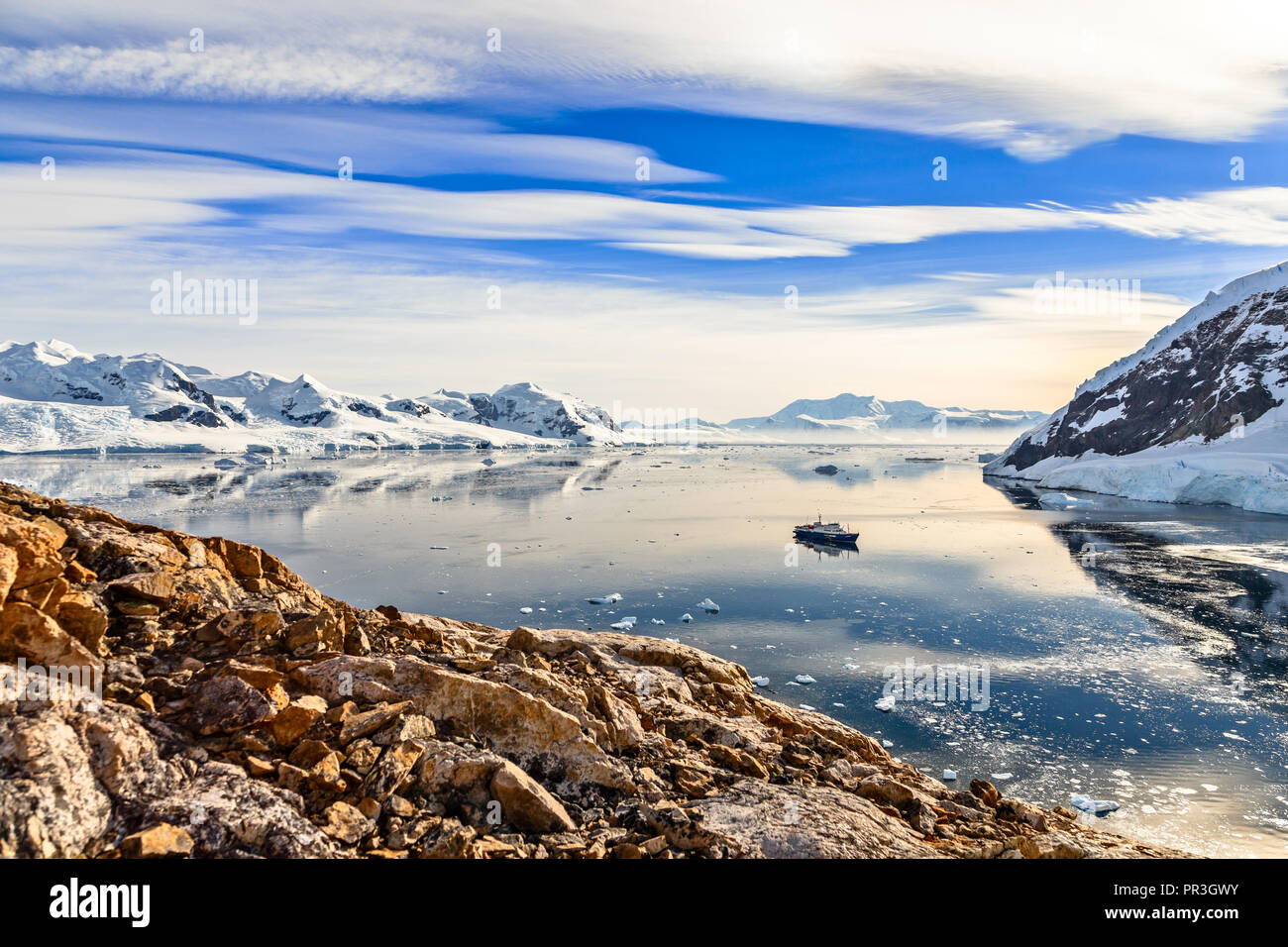 Bateau de croisière antarctique entre les icebergs et manchots réunis sur la rive de la baie de Neco, Antarctique Banque D'Images
