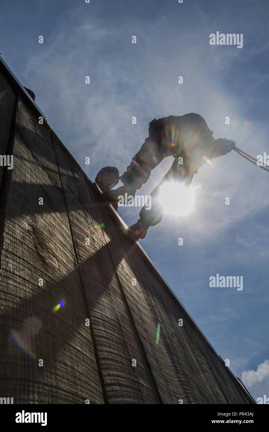 Un U.S. Naval ROTC Aspirant de rappels en bas d'un mur au cours de formation axés sur la carrière pour les aspirants de marine (CORTRAMID) Semaine, Camp Lejeune, N.C., 25 juillet 2017. Le but d'CORTRAMID consiste à exposer les étudiants aux possibilités de la flotte maritime Forces et générer un intérêt dans une commission du Corps des Marines. Banque D'Images