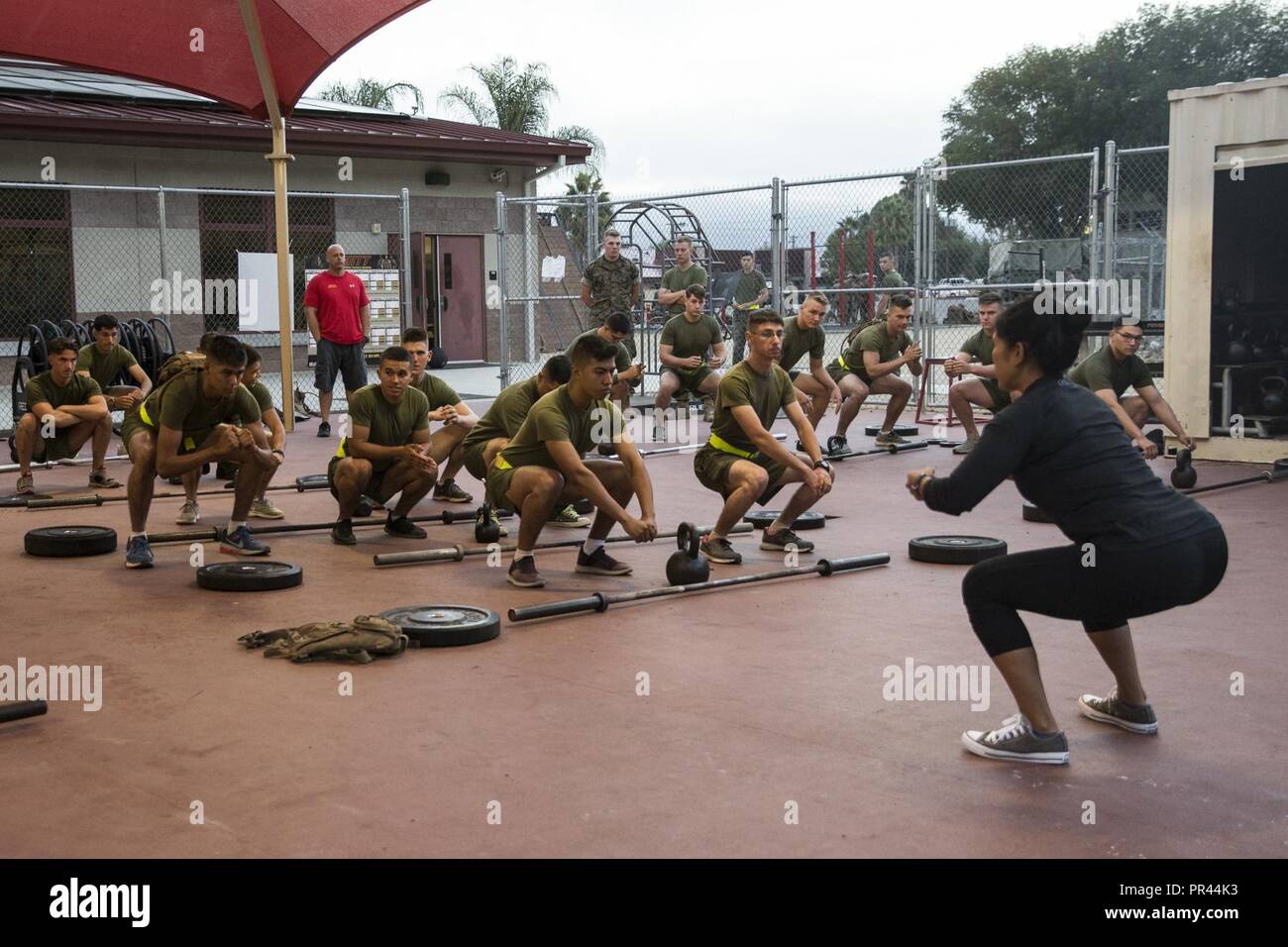 Roxanne Casinio, instructeur, Semper Fit, Marine Corps Community Services, démontre un bon squat pour les Marines américains avec la Compagnie Golf du 2e bataillon du 1er Régiment de Marines, 1 Division de marines, pendant une forte intensité de l'entraînement tactique à la classe 43 Salon centre de remise en forme au Marine Corps Base Camp Pendleton, en Californie, le 6 septembre 2018. Casinio et collègues moniteurs Marines a enseigné comment mieux leur squat et soulevé de formes, et a expliqué la différence entre l'endurance et l'énergie explosive pendant l'entraînement. Banque D'Images