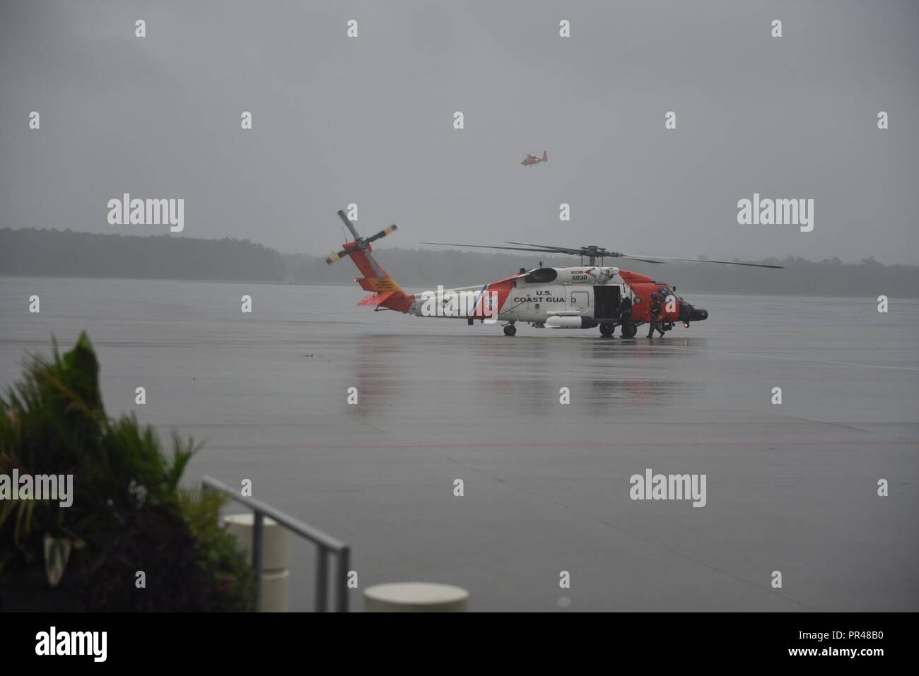 Une Garde côtière canadienne d'hélicoptères Jayhawk MH-60 équipage se prépare à quitter la plage de myrte, L.C. après l'avitaillement. L'équipage de l'hélicoptère n'est pas endommagé et les évaluations de la zone de crue de l'ouragan Florence. Banque D'Images