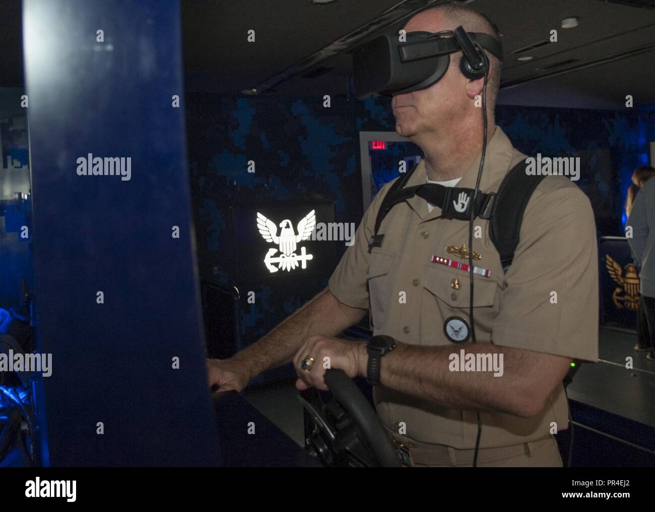 MILLINGTON, Tennessee (sept. 12, 2018) Le recrutement dans la Marine, Commandant, Commandement SMA arrière. Brendan R. McLane a eu l'occasion de l'expérience de la Marine, de l'actif de réalité virtuelle du le "Nimitz", lors d'une visite prévue à Millington Central High School. L'expérience consiste à passer par une série d'exercices, en commençant par un exposé, avant de participer à une grande vitesse virtuelle l'extraction de l'eau d'un Navy SEAL team c'est coincé sous le feu de l'ennemi. Le Nimitz est nommé d'après le SMA de la flotte. Chester Nimitz, originaire de Fredericksburg, au Texas, qui a commandé la Flotte américaine du Pacifique pendant la DEUXIÈME GUERRE MONDIALE. Banque D'Images