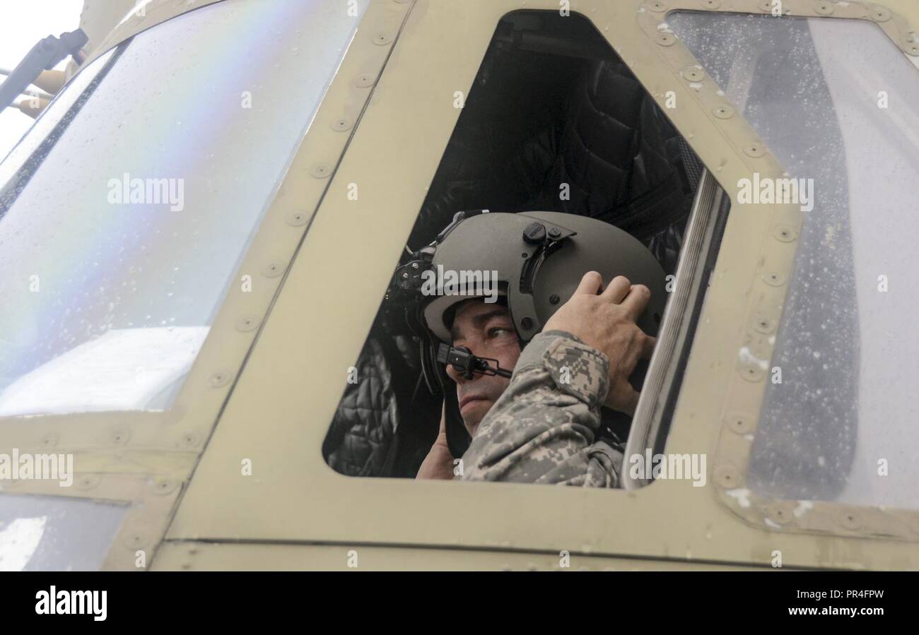 L'Adjudant-chef Patrick 4 Donohue, un CH-47 Chinook de l'Armée de l'Est avec le pilote de la formation de l'Aviation Site (EAATS), met son casque avant le décollage le 13 septembre de Muir Army Airfield à Fort Indiantown Gap, en Pennsylvanie. Environ 25 membres de la garde en Pennsylvanie et chinook deux deux hélicoptères Black Hawk UH-56, qui sont tenus de Caroline du Sud à l'appui de l'ouragan Florence les efforts de rétablissement. Banque D'Images