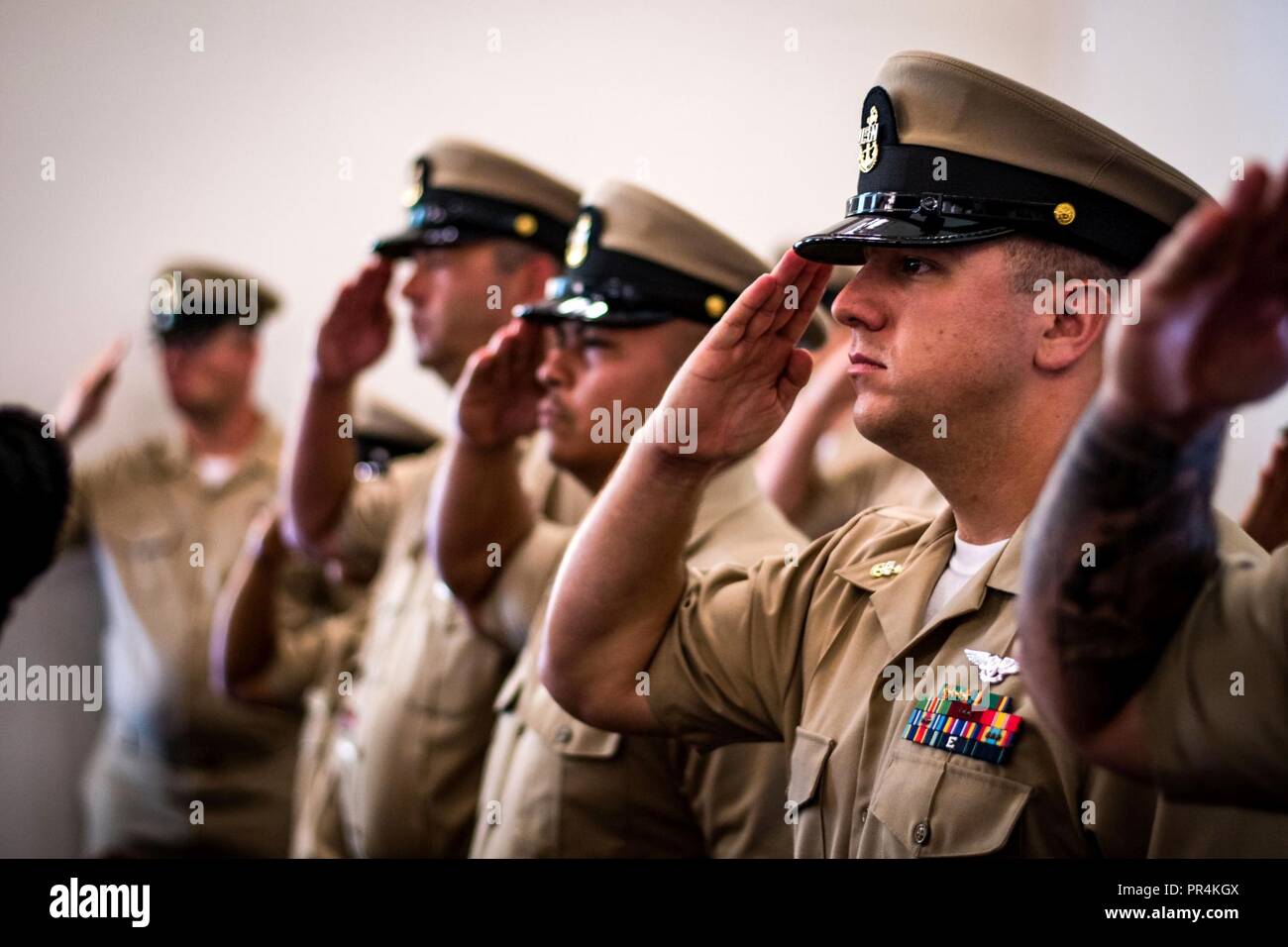 DIEGO (sept. 14, 2018) l'aviation en chef Ordnanceman Dustin James, affecté à l'assaut amphibie USS Makin Island (DG 8), rend hommage au cours d'une cérémonie à l'épinglage en chef de la base navale de la chapelle de San Diego. Huit marins ont été promu premier maître au cours de la cérémonie. L'île de Makin, homeported à San Diego, est la réalisation d'une maintenance au niveau du dépôt de la disponibilité. Banque D'Images