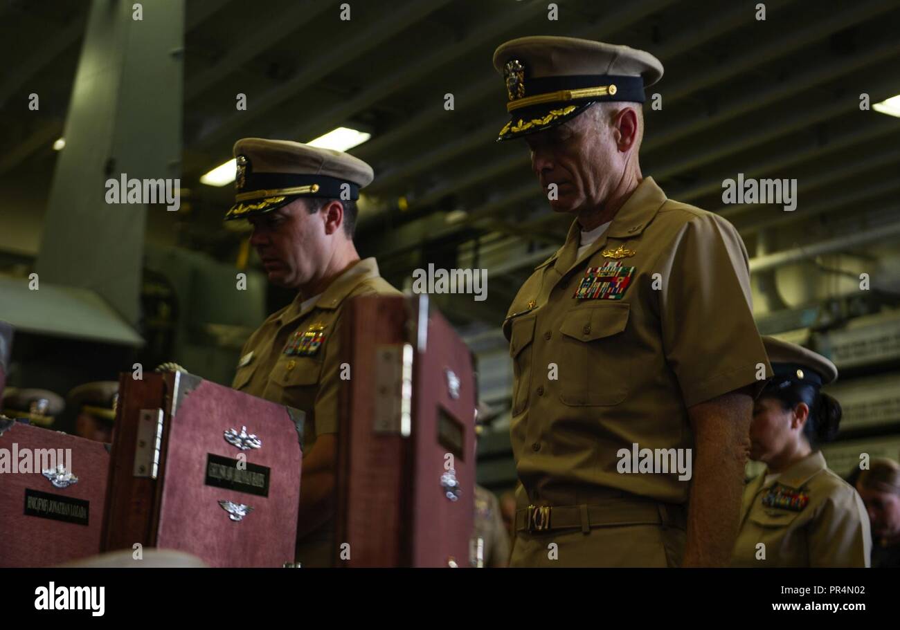 D'ADEN (sept. 142018) -Le Cmdr. Bradley Coletti, directeur général de guêpe-classe d'assaut amphibie USS Essex (DG 2), et le Capitaine Gerald Olin, commandant de l'Escadron 1, Amphibie, baissent la tête dans la prière au cours d'un premier maître de cérémonie tout en épinglant en fonction d'un programme de déploiement du groupe amphibie d'Essex (ARG) et 13e Marine Expeditionary Unit (MEU). L'Essex ARG/13e MEU est un lethal, flexible, et les polluants Navy-Marine Corps équipe déployée à la 5e flotte américaine zone d'opérations à l'appui des opérations navales pour assurer la stabilité et la sécurité maritime dans la partie centrale de Regi Banque D'Images