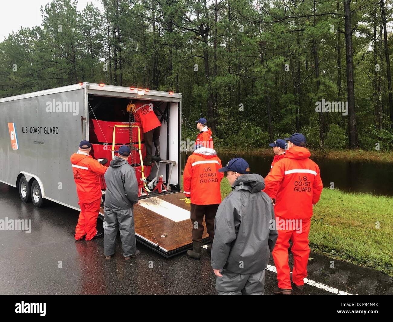 Les membres de la Garde côtière canadienne de l'eau peu profonde à l'équipe de déchargement du bateau de sauvetage de trois bateaux de sauvetage pour aider les personnes touchées par des inondations causées par l'ouragan Florence, à Riegelwood, Caroline du Nord, Sept 16, 2018. Banque D'Images