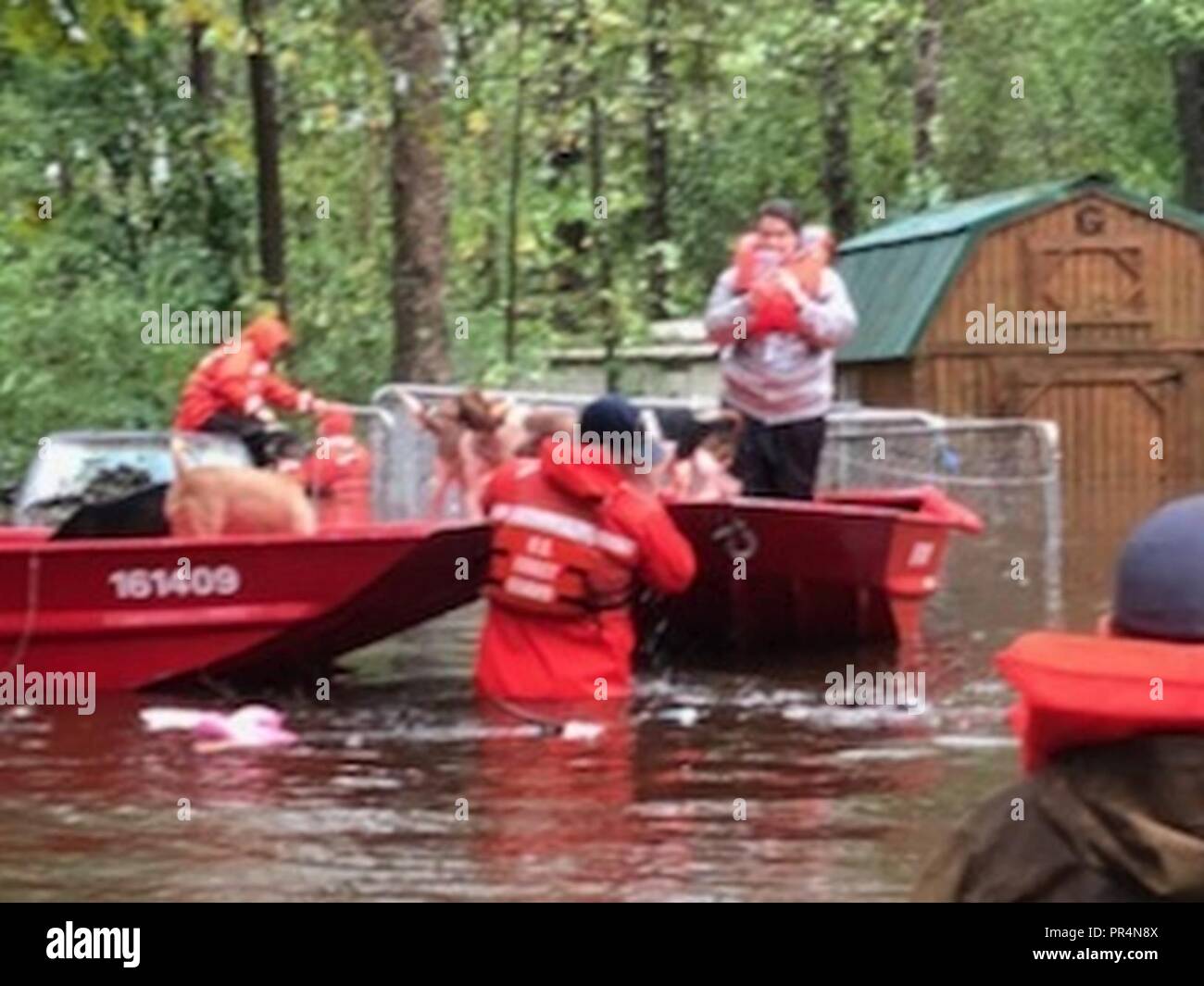 Les membres de l'eau peu profonde de la Garde côtière canadienne équipe bateau Réponse 3 aider les gens bloqués par l'eau de l'inondation causée par l'ouragan Florence près de Riegelwood, Caroline du Nord, le 16 septembre 2018. Banque D'Images