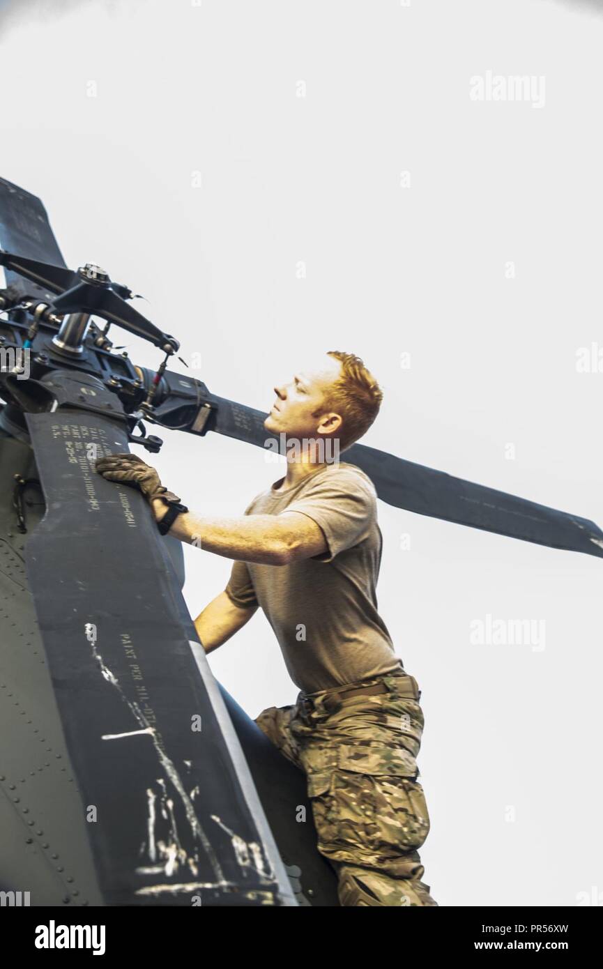 Ingénieur de vol TSgt Christian Meyers preps son hélicoptère et inspecte le rotor pour s'assurer que l'avion est prêt à appuyer les missions de recherche et sauvetage dans les domaines de la Caroline du Nord touchés par l'ouragan Florence. Banque D'Images