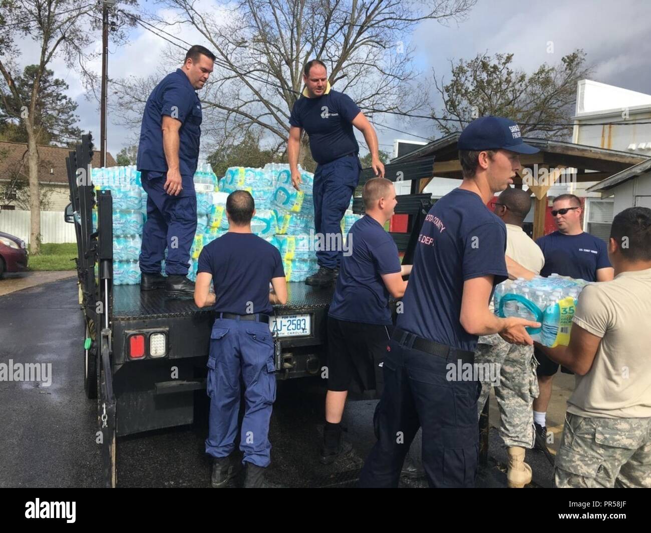 Le personnel de la Garde côtière de distribuer de l'eau embouteillée aux résidants de Newport, North Carolina, touchées par les inondations causées par l'ouragan Florence 17 Septembre, 2018. La Garde côtière a entrepris des opérations de recherche et de sauvetage à l'appui d'État et locaux des centres d'opération d'urgence. Banque D'Images