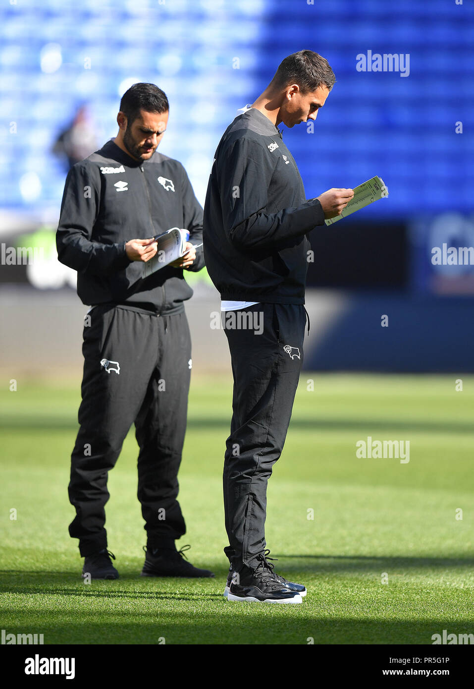Derby County's Bradley Johnson (à gauche) lit le programme avant le match de championnat Sky Bet à l'Université de Bolton Stadium. Banque D'Images