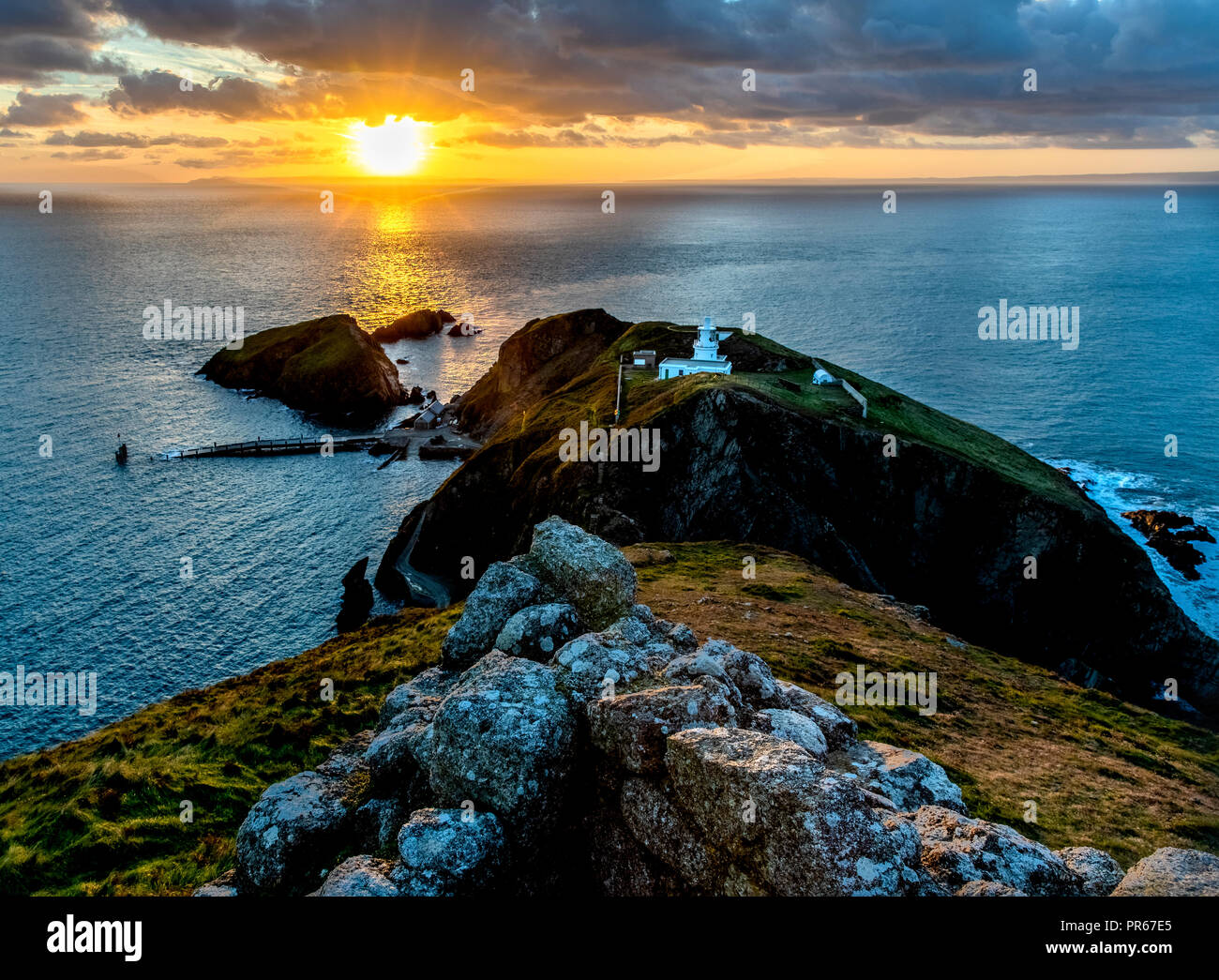 Lever du soleil sur le Sud de la lumière et le phare d'atterrissage Oldenberg jetty de Marisco Castle sur l'île de Lundy au large de la côte du Devon UK Banque D'Images