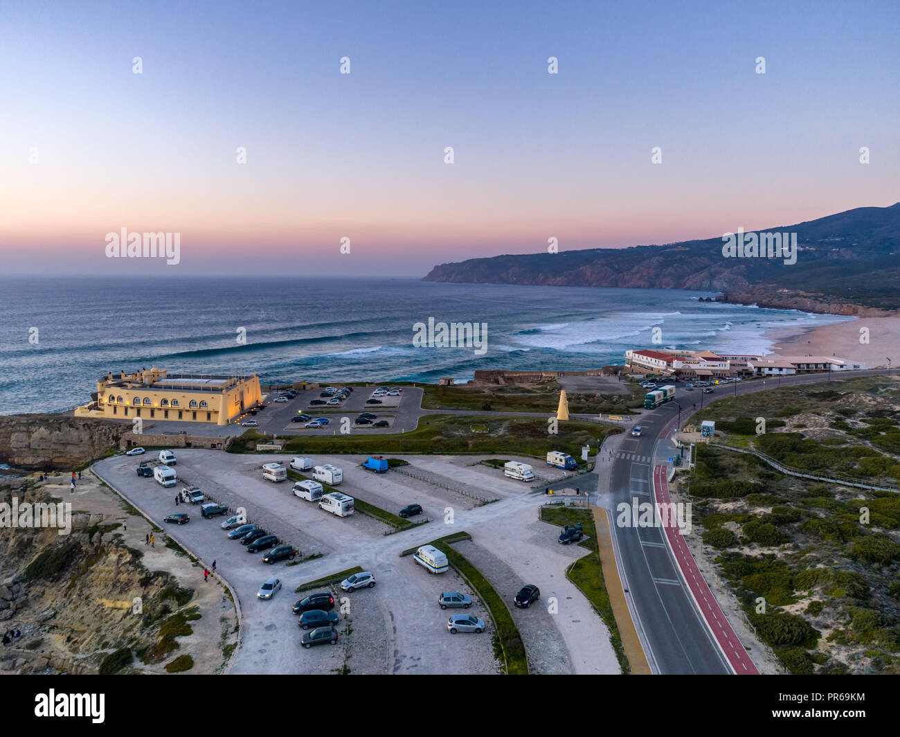 Dronephoto aérienne de Praia do Guincho Beach et l'hôtel Fortaleza au coucher du soleil à Sintra, Portugal Banque D'Images