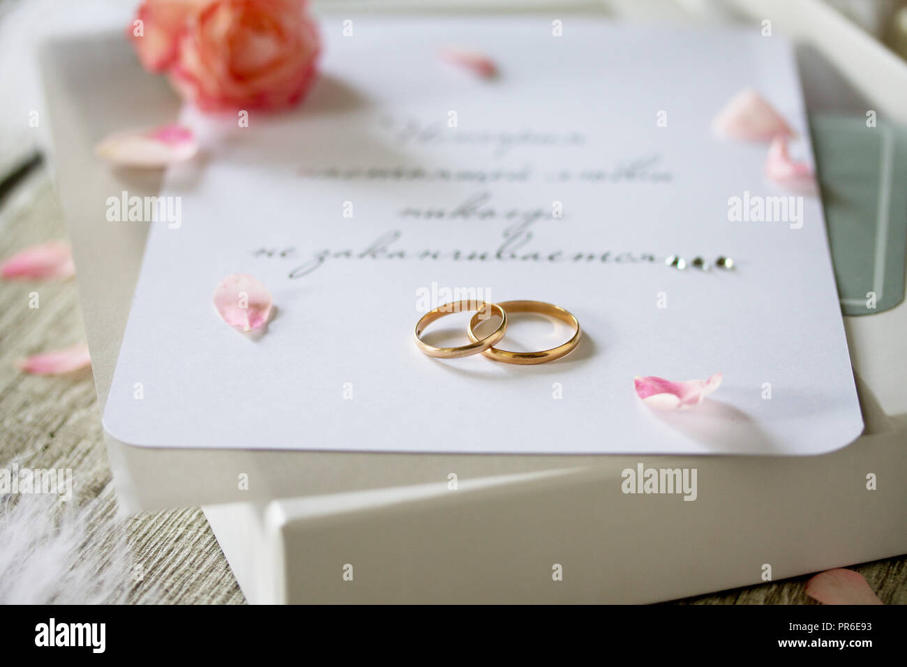 Deux bagues en or, une boîte de chocolats et une invitation de mariage, une inscription que l'histoire de l'amour vrai ne se termine jamais, close-up. Banque D'Images