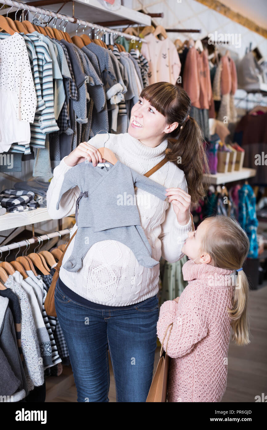 Femme enceinte avec la fille le choix des curseurs pour magasin de  vêtements pour enfants Photo Stock - Alamy