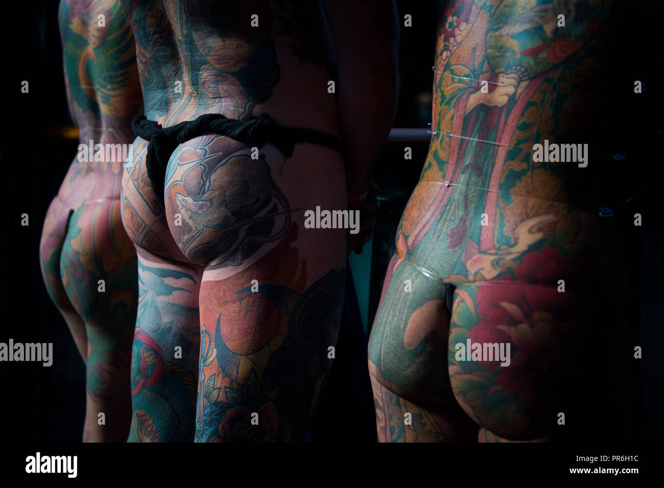 Les gens montrent leurs tatouages au cours de l'International Tattoo convention au quai du tabac dans l'Est de Londres. Banque D'Images