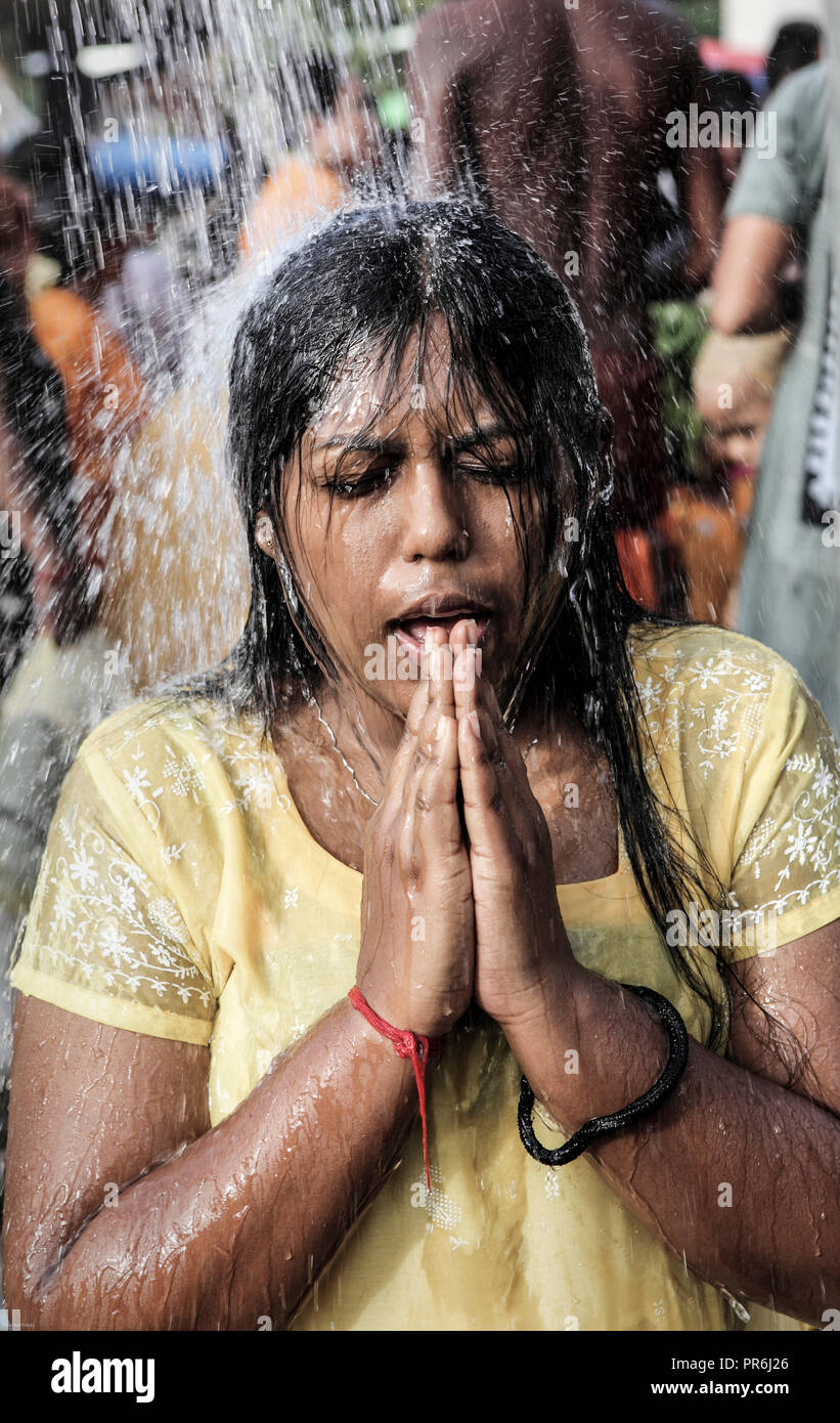 Femme adore sous l'eau douche pendant Thaipusam festival à Batu Caves à Selangor, Malaisie Banque D'Images