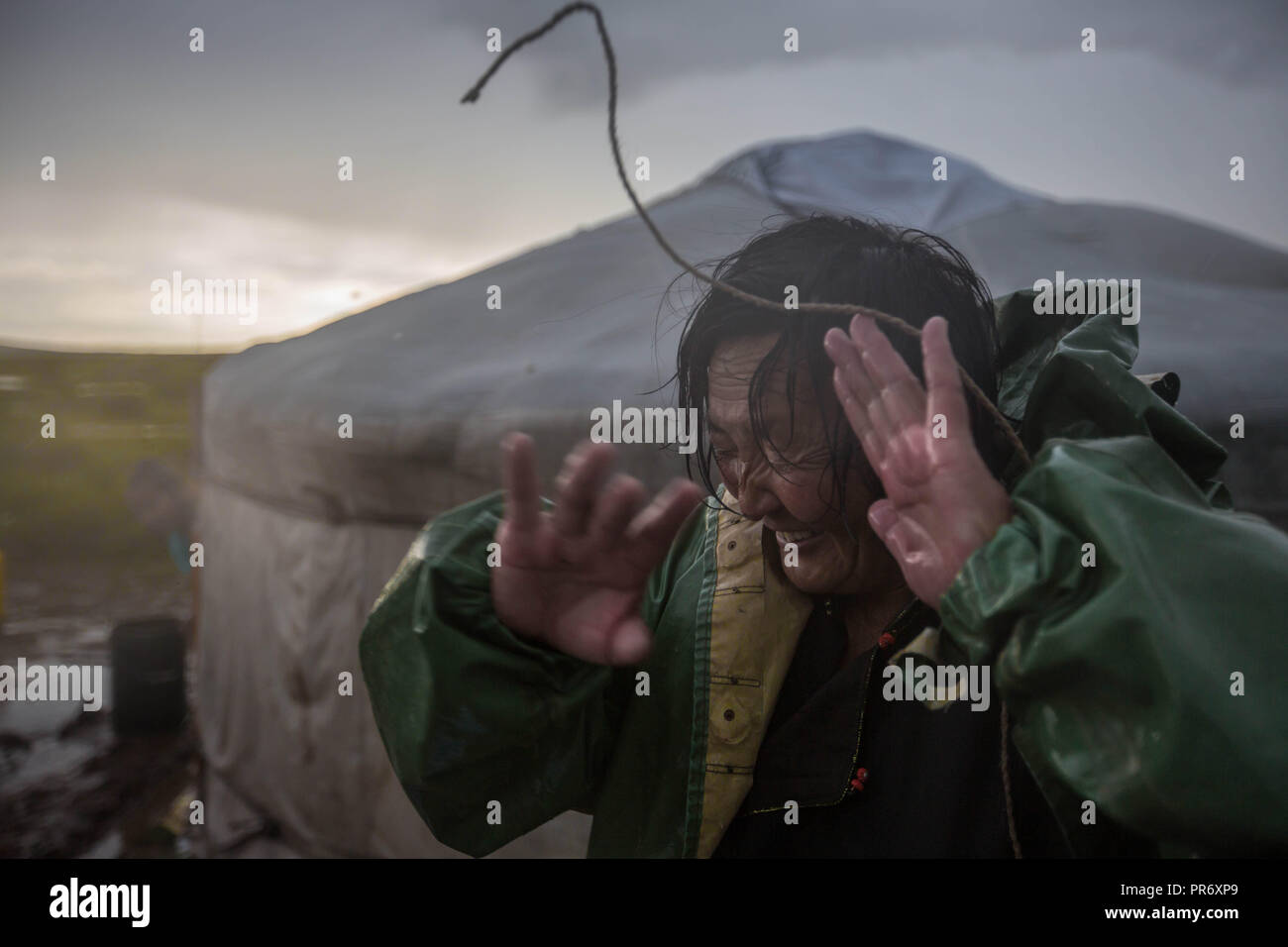 Une femme lutte pour creuser une tranchée autour de sa maison pendant une forte tempête près du petit village de Lün Töv en province, la Mongolie. Banque D'Images