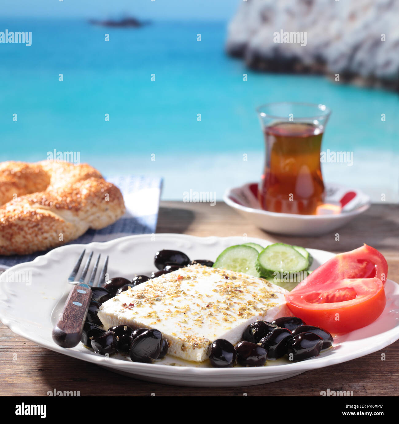 Le petit-déjeuner avec fromage feta, olives, simit, les légumes et le thé contre mer Méditerranée Banque D'Images