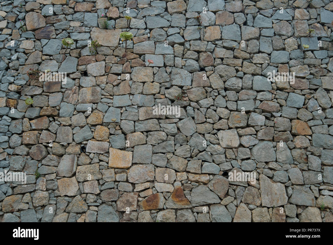 Mur en pierres naturelles de fond. la texture d'un mur de pierre - Banque D'Images