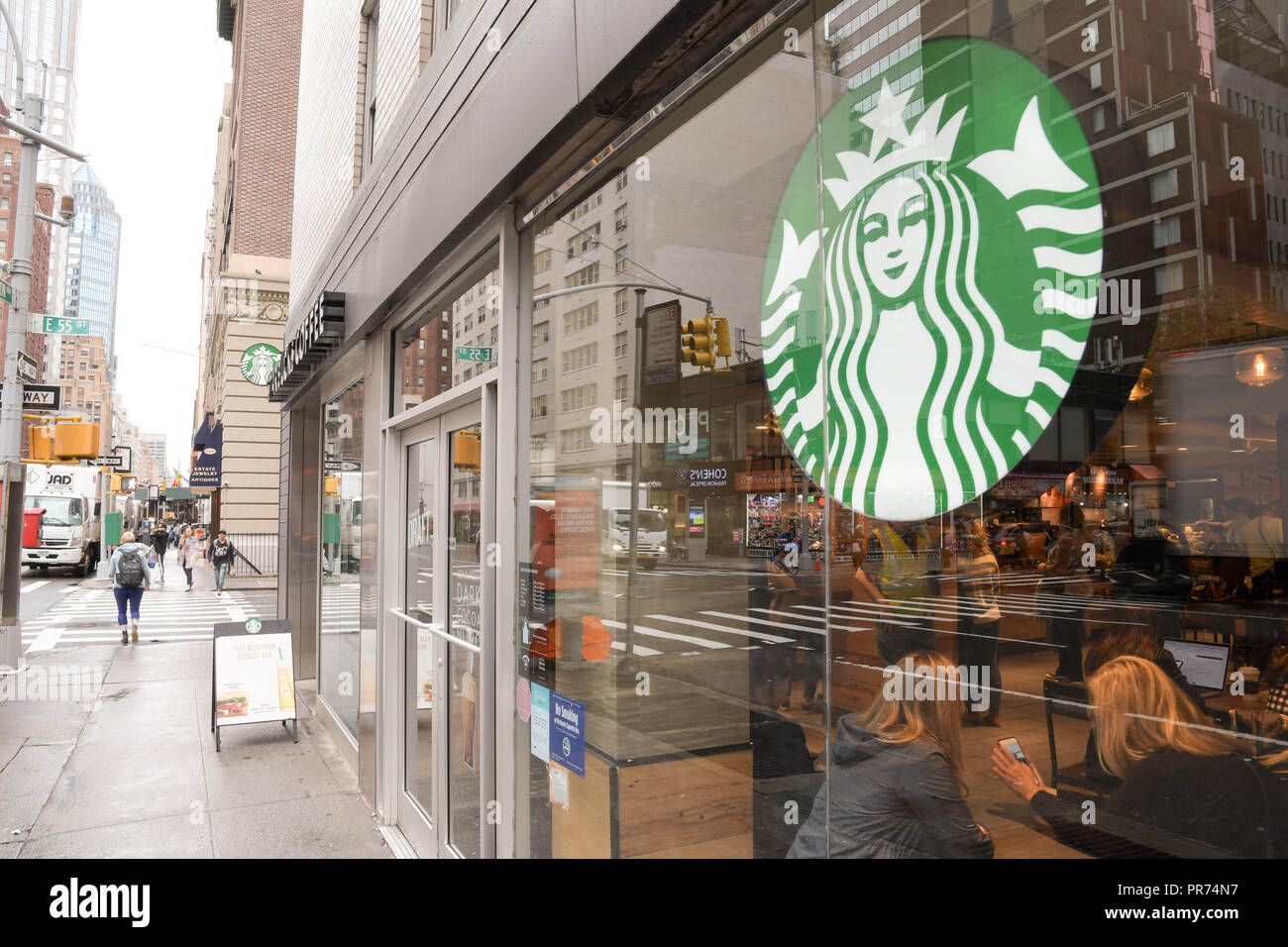 Les clients de remplir un Starbucks sur la Cinquième Avenue à New York City sur un ciel nuageux matin de septembre. Banque D'Images