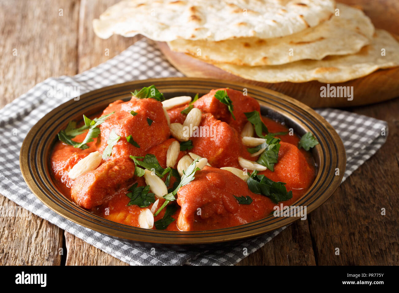 Recette traditionnelle du beurre Murgh Makhani Poulet en sauce épicée avec des amandes et de la coriandre close-up avec roti sur la table horizontale. Banque D'Images