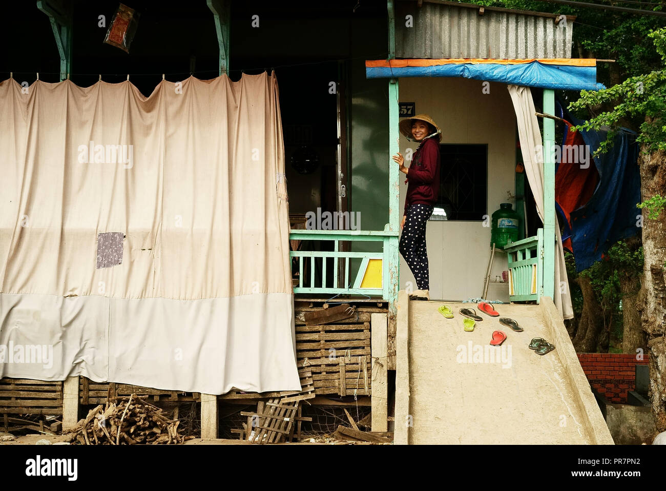 Fille devant sa maison sur pilotis, le long de la rivière Hau, Chau Doc, Delta du Mékong, au Vietnam, à la frontière cambodgienne. Banque D'Images