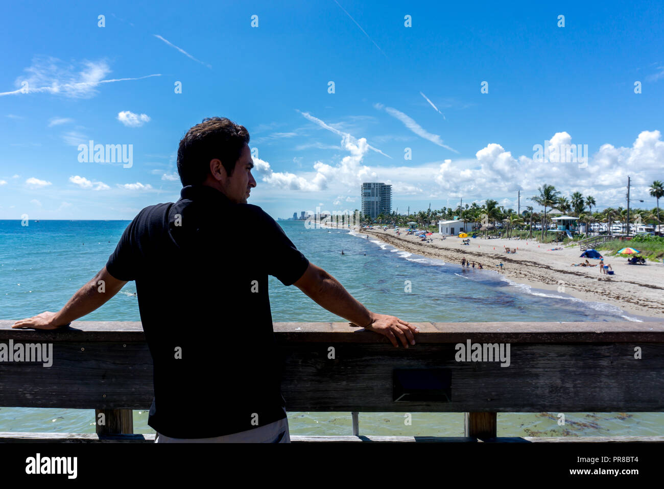 Jeune homme à la recherche au niveau de la vue de Dania Beach à Miami, en Floride. Journée ensoleillée d'été avec beaucoup de gens dans l'eau Banque D'Images