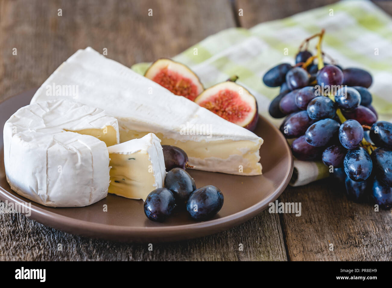 Fromage avec fig et raisins sur table en bois. Banque D'Images