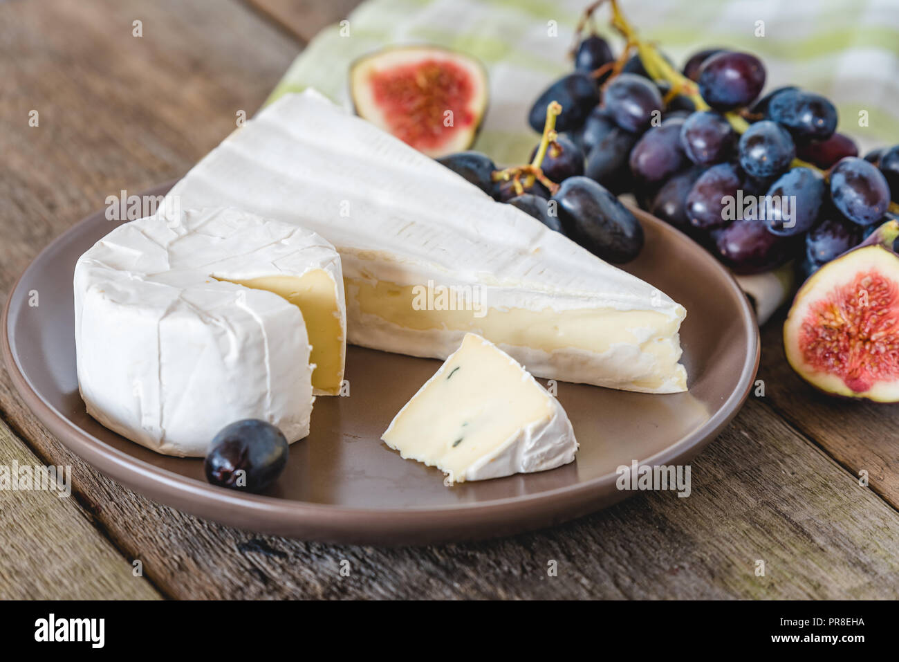 Fromage avec fig et raisins sur table en bois. Banque D'Images