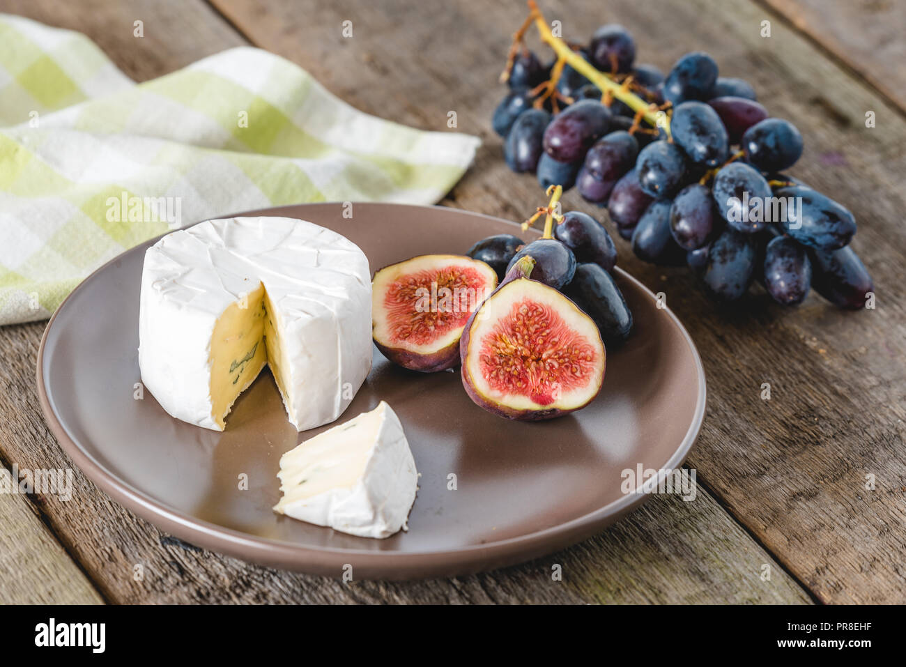 Fromage avec fig et raisins sur table en bois. Banque D'Images