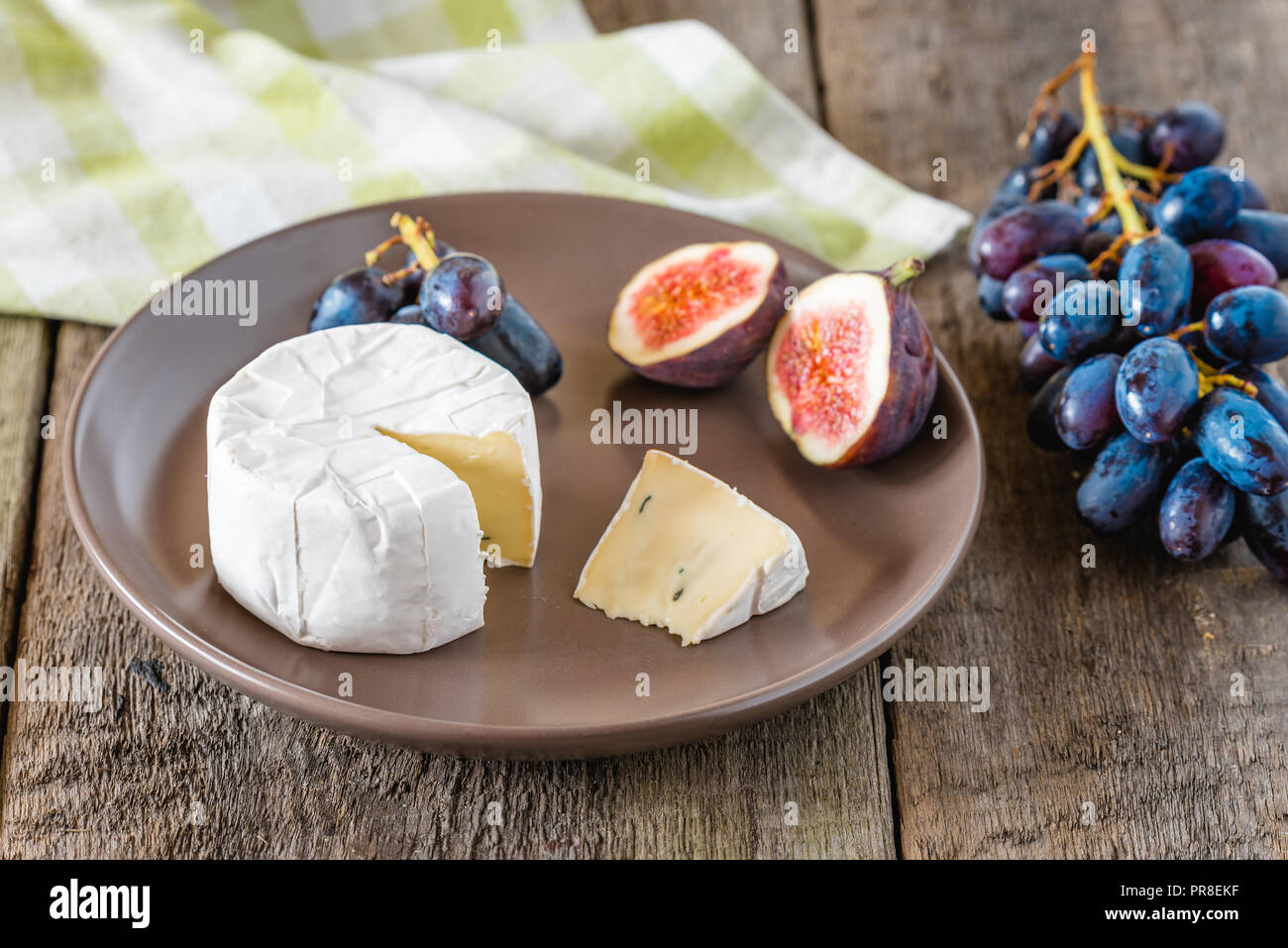 Fromage avec fig et raisins sur table en bois. Banque D'Images