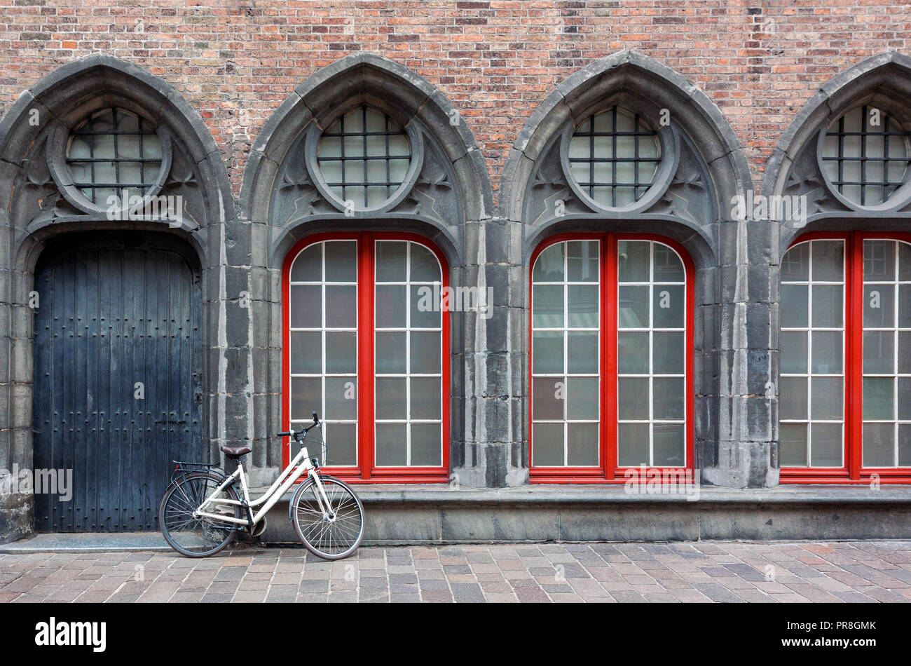 Location solitaire debout contre le mur de l'ancien bâtiment historique de Bruges, Belgique Banque D'Images