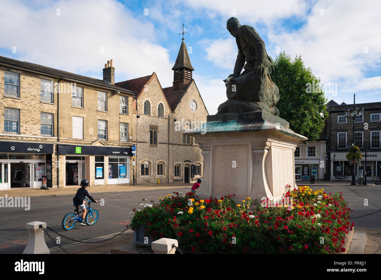 War Memorial UK ville, vue d'un vélo enfant passé un mémorial de guerre à Bury St Edmunds, Suffolk place du marché, de l'East Anglia, Royaume-Uni. Banque D'Images