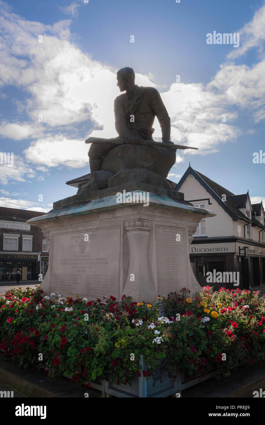 Monument commémoratif de guerre du Royaume-Uni, en vue d'un monument représentant un soldat fatigué en silhouette contre le soleil, les nuages, la place du marché de Bury St Edmunds, Suffolk UK Banque D'Images