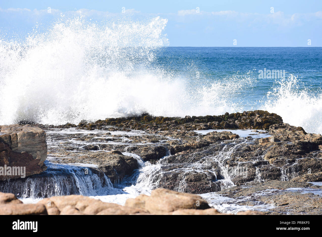 S'écraser les vagues et l'eau qui coule sur les rochers côtiers, d'Uvongo, Afrique du Sud Banque D'Images