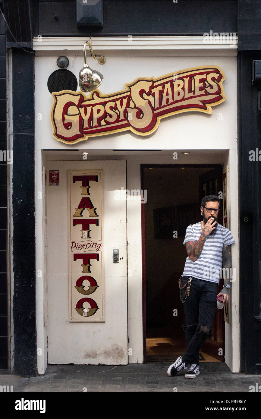Un tatoueur très cool a une pause à l'extérieur de son studio de tatouage, Gypsy stables à Soho Banque D'Images