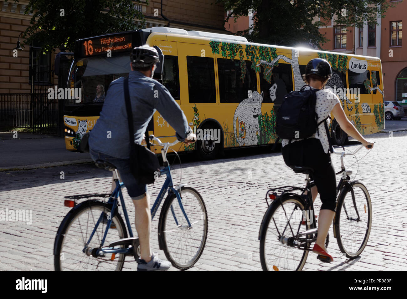 Helsinki, Finlande - 15 juillet 2017 : personnes à vélo contre l'autobus sur la ligne 16 pour se rendre au zoo d'Helsinki. Banque D'Images