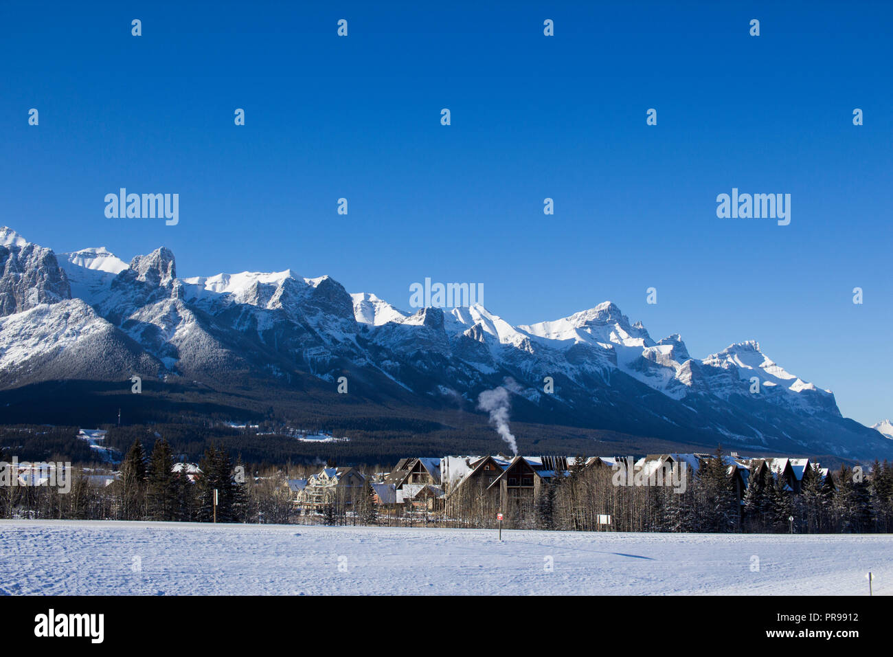 Massif du Mont Rundle à Canmore, en Alberta, lors d'une journée ensoleillée sur le village au premier plan. Banque D'Images