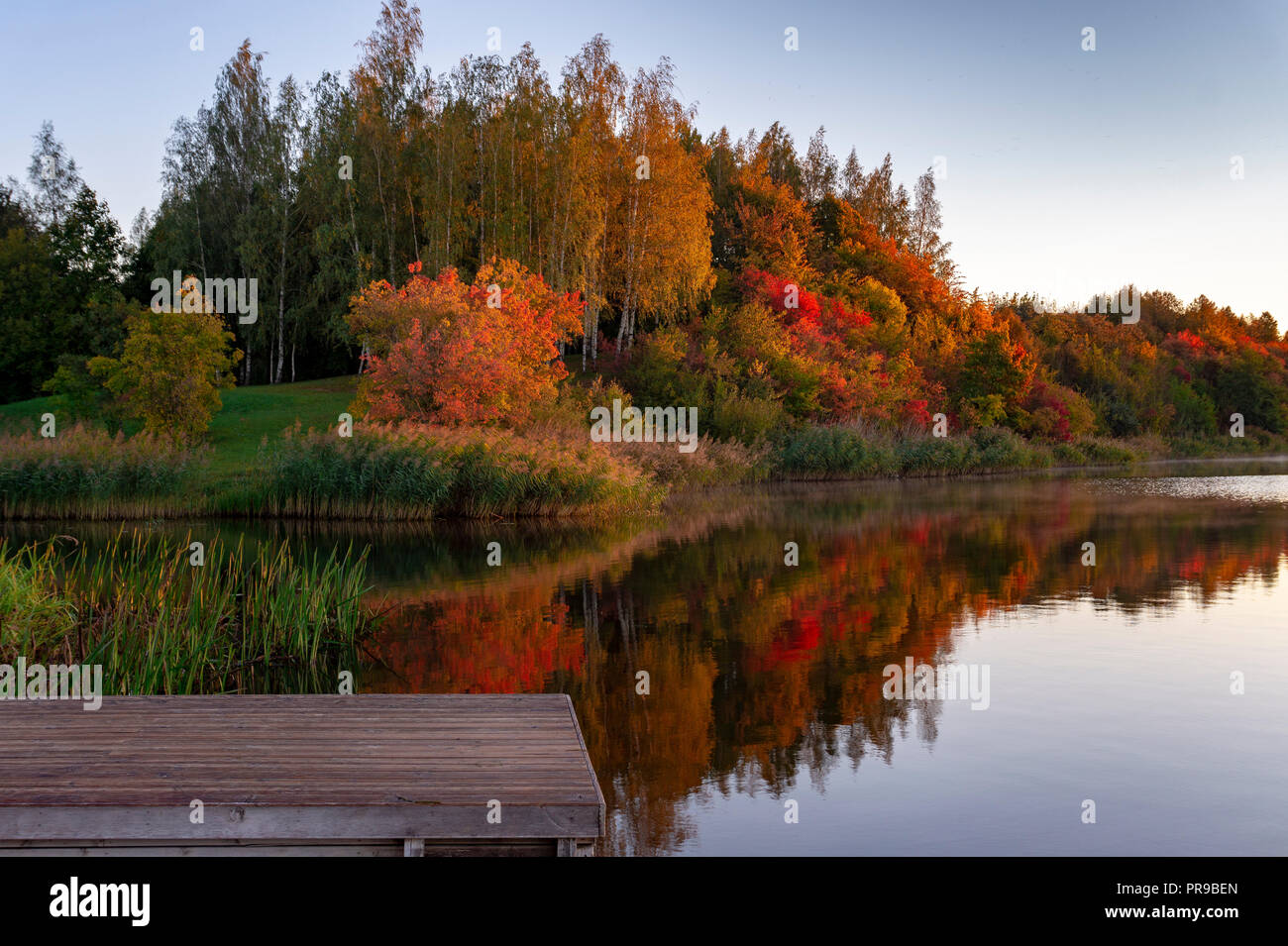 Début de saison automne lac idyllique réflexions de feuillage d'automne. Feuillage automne coloré jette son reflet sur les eaux calmes Banque D'Images