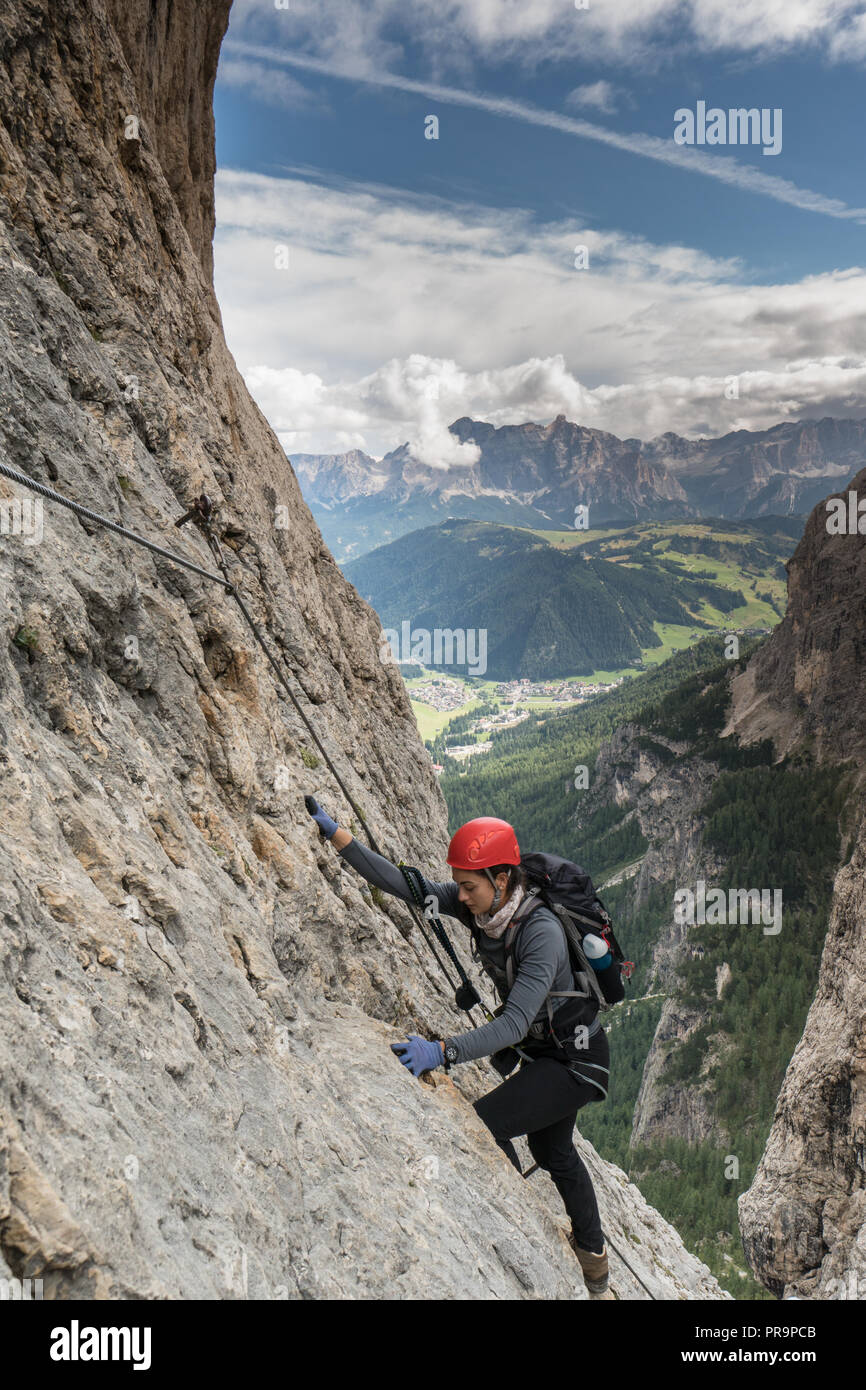 Les jeunes femmes attrayantes d'alpiniste sur une difficile via ferrata dans les Dolomites en Alta Badia dans le Sud Tyrol en Italie Banque D'Images